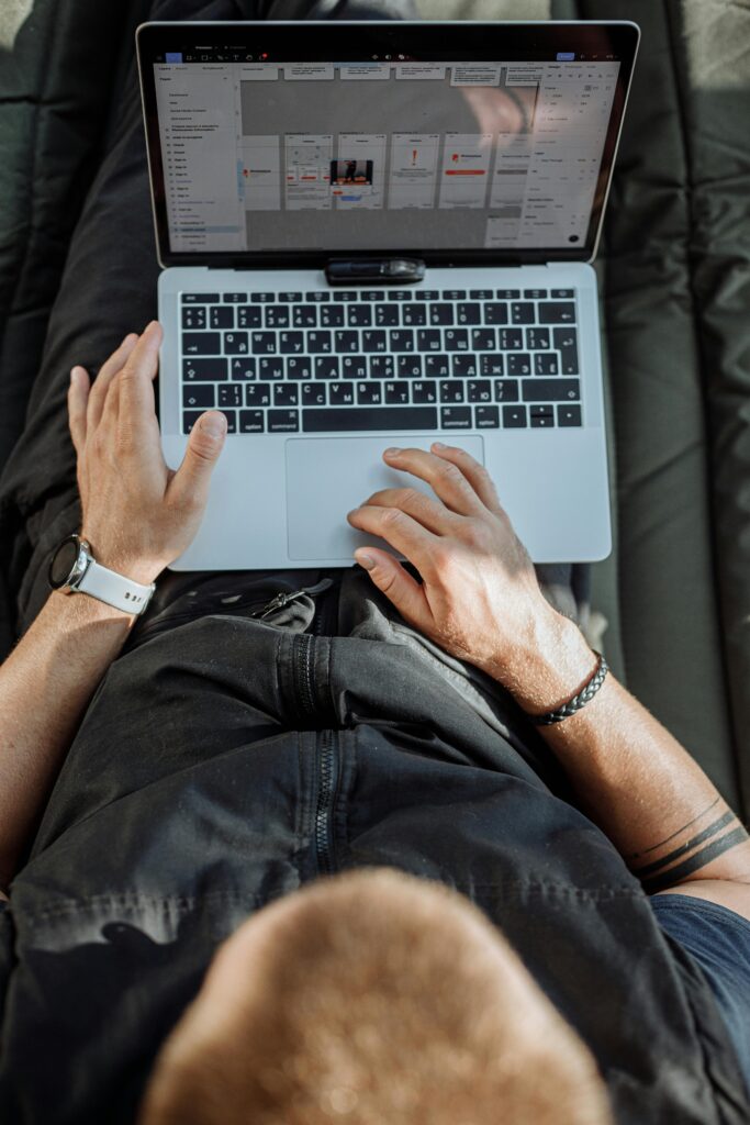 pexels-photo-5052659-5052659 Overhead view of an adult typing on a laptop, symbolizing remote work and digital nomad lifestyle.